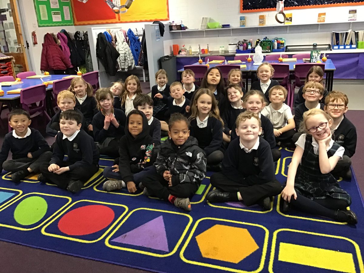 Class sitting together on the classroom carpet