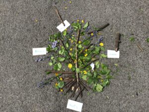 A nature-inspired artwork made with leaves, twigs and flowers