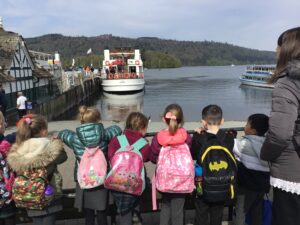 Year 1 children watching boats beside the lake on a school trip